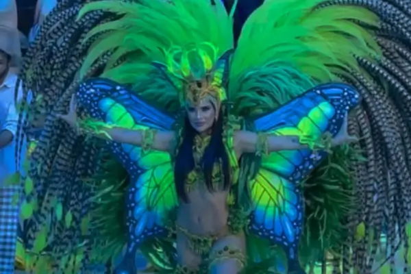 Dançarina com fantasia de borboleta em verde e azul se apresenta no Festival de Parintins, no Amazonas.