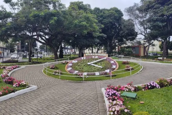 Relógio das Flores em Garanhuns, Pernambuco, com números feitos de plantas e flores coloridas, cercado por canteiros e árvores.